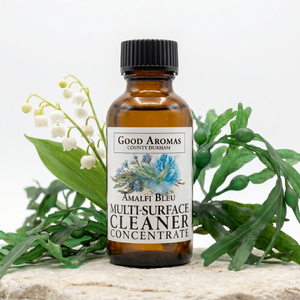 Bottle of Good Aromas multi-surface cleaner concentrate with greenery on a light background